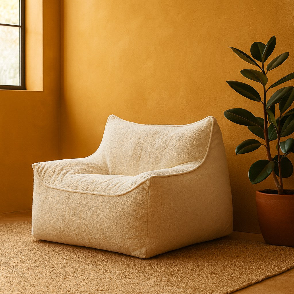 Poltrona Dália numa sala de parede ocre, com tapete de fibra natural e planta ao lado
