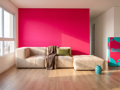 Sofá Lótus numa sala com parede rosa, com a caixa Bloom ao lado
